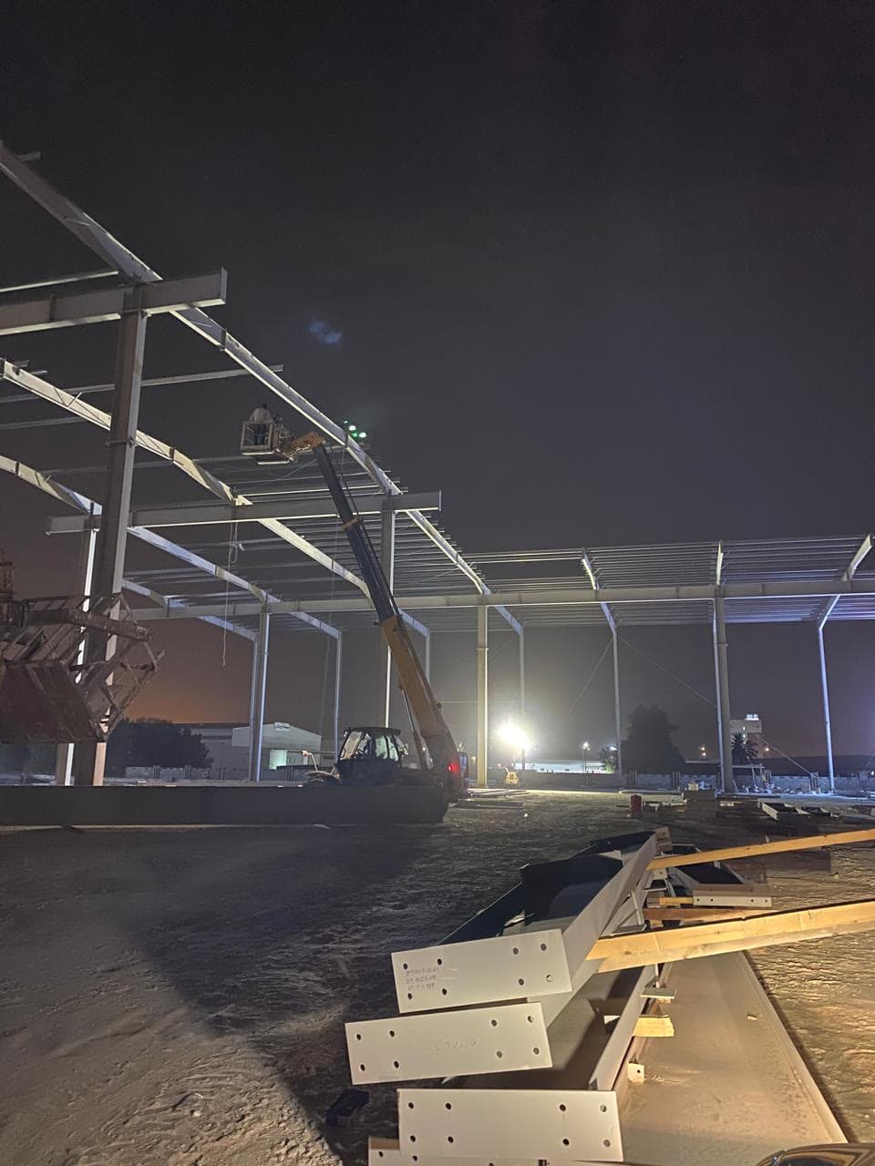 Steel portal frames rising at night